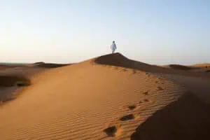 Omani-man-walking-on-dunes-©-Ministry-of-Heritage-&-Tourism-Sultanate-of-Oman